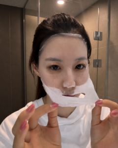 Ah-young Kim applying a sheet mask during her Korean summer skincare routine