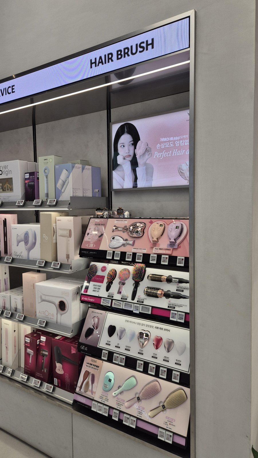 Hair brushes and accessories displayed beneath the Hair Brush sign at Olive Young